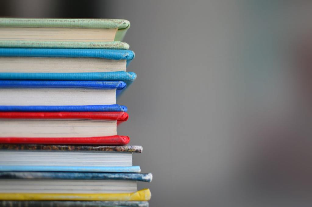 Libros y taza de café junto a una ventana
